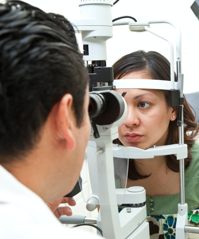 female patient head resting and looking into eye exam machine