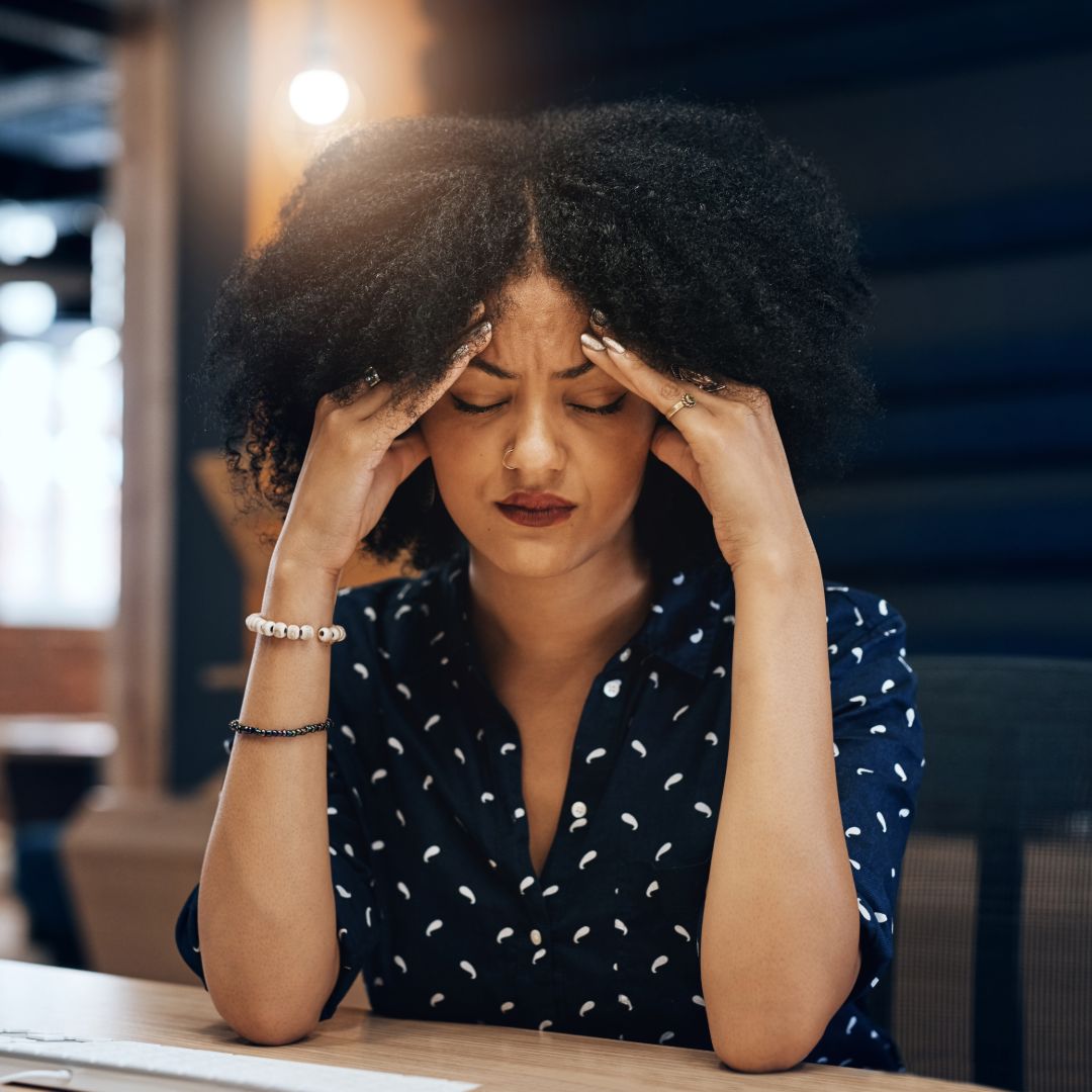 Shot of a tired young female designer looking stressed with her hands in her hair while contemplating in the office at work