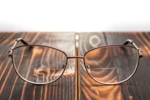 eyeglasses with bifocal lenses on wooden board