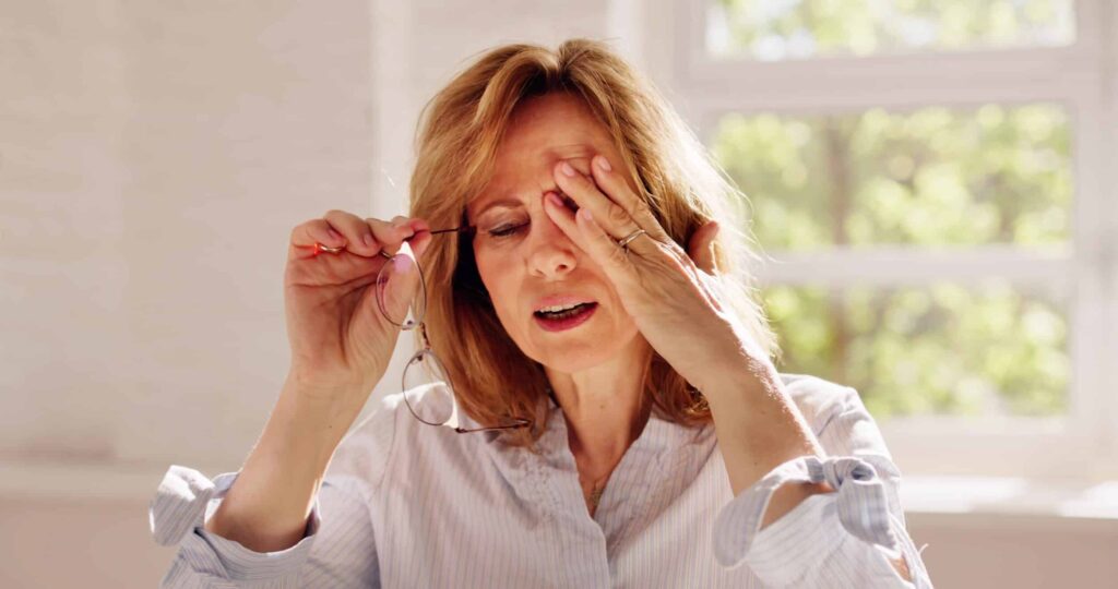 5 Early Warning Signs of Diabetic Eye Disease You Shouldn’t Ignore 1 Older woman holding glasses and rubbing eyes from diabetic eye disease symptom in Chesapeake