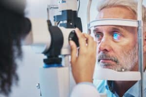 Older man having eyes examined before minimally invasive glaucoma surgery in Chesapeake, VA